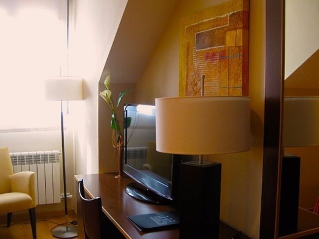 una habitación con un televisor y una lámpara y un cuadro en la pared