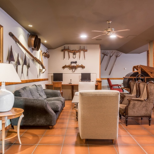 a living room with a couch chairs and a lamp