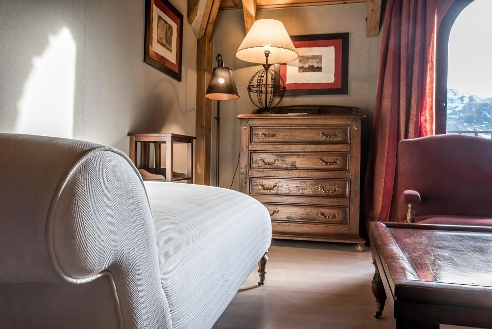 una habitación con un sofá blanco y una cómoda de madera