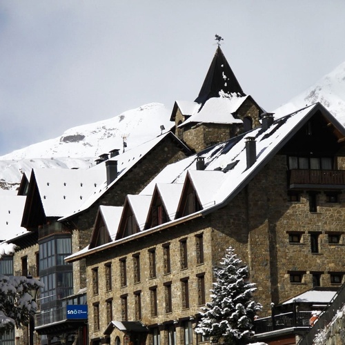 a building with snow on the roof has a blue sign that says ibis