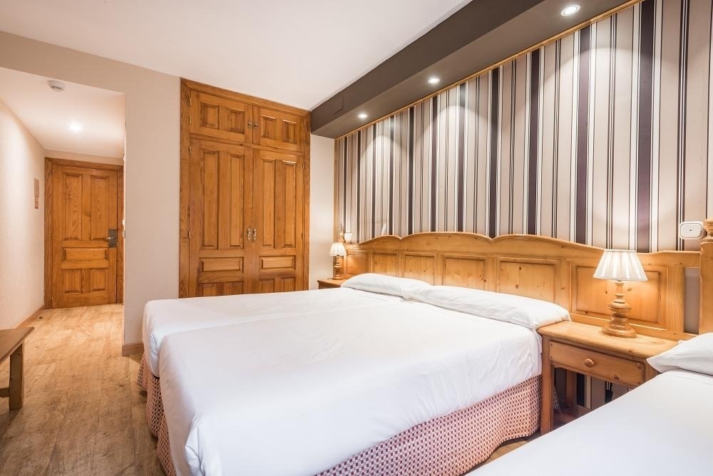 una habitación con dos camas y dos mesitas de noche