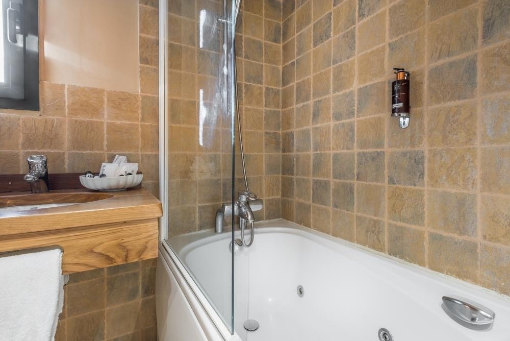 un baño con una bañera y un lavabo de madera
