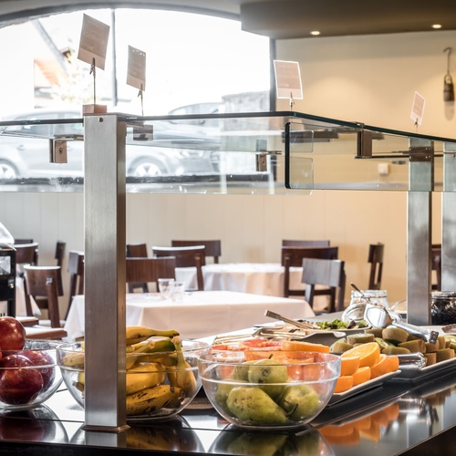 a buffet with bowls of fruit and a vending machine that says ' mone ' on it