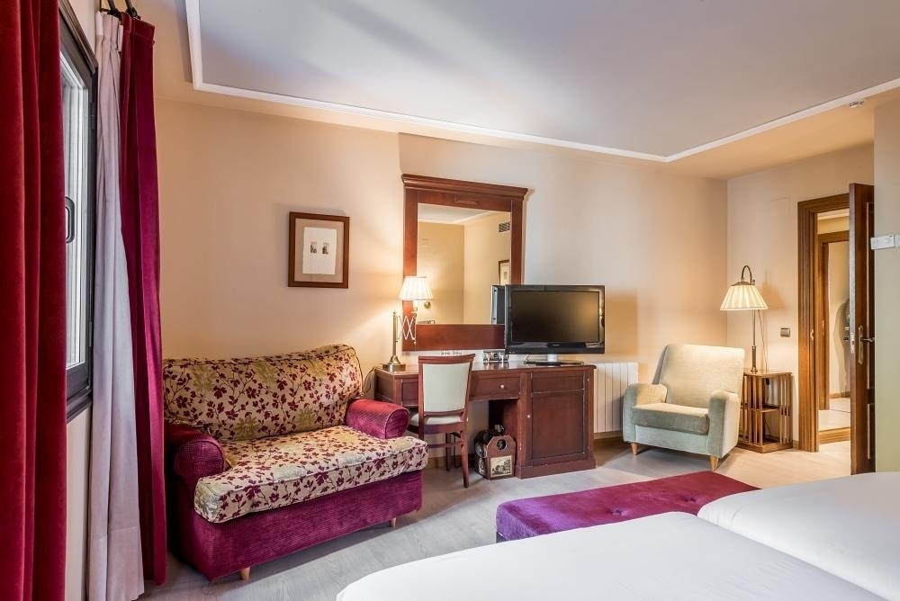 una habitación de hotel con dos camas y una televisión