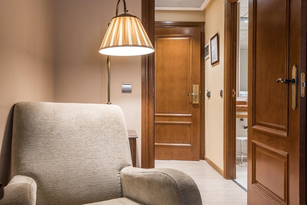 una silla y una lámpara en una habitación con una puerta de madera