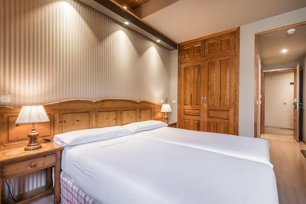 una habitación con dos camas y un armario de madera