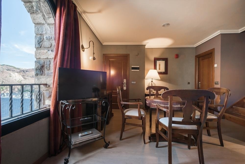 una habitación con una mesa y sillas y una televisión