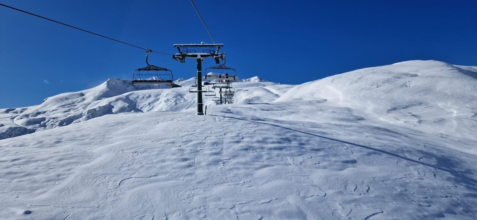 un téléski avec une montagne enneigée en arrière-plan