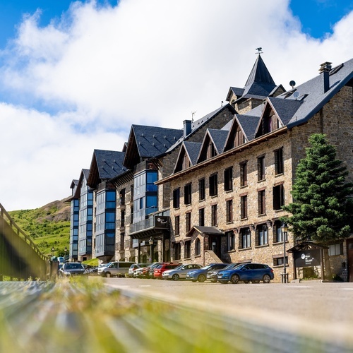 a row of cars are parked in front of a large stone building