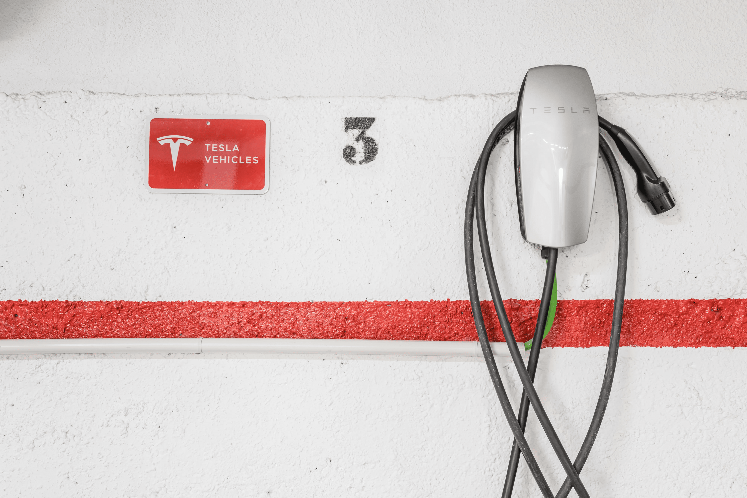 a sign on a wall that says tesla vehicles