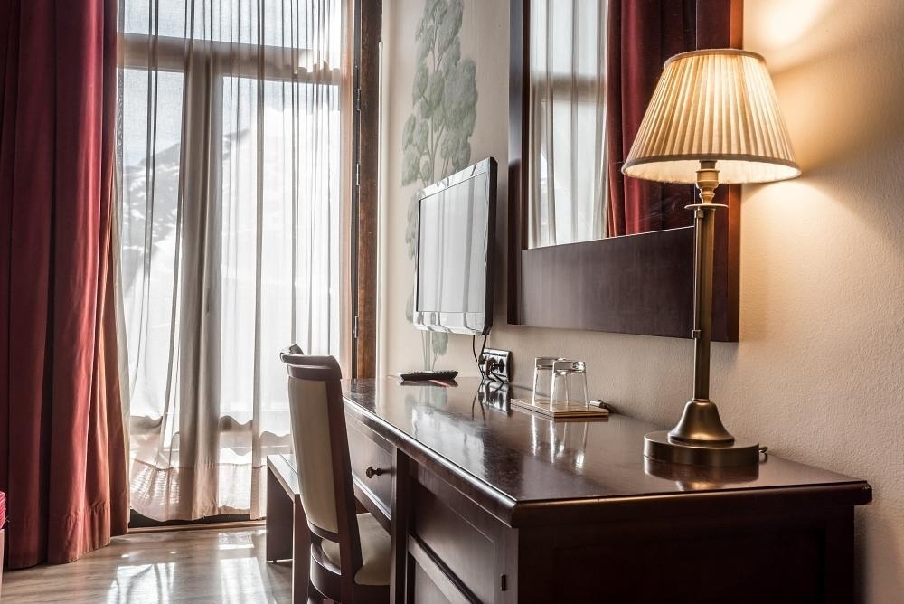 una habitación de hotel con un escritorio y una lámpara