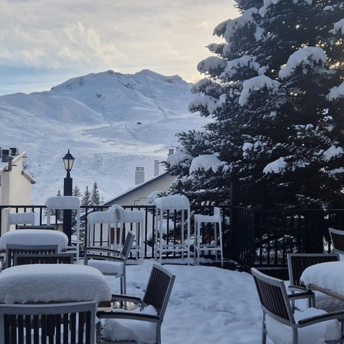 SNO: Villa de Sallent 4* covered in snow, with snowy mountains in the background.