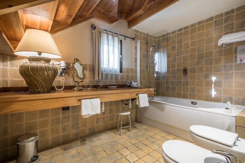 un baño con bañera , inodoro y lavabo de madera