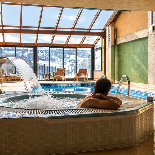 Homme se relaxant dans un jacuzzi avec cascade à SNO: Villa de Sallent 4