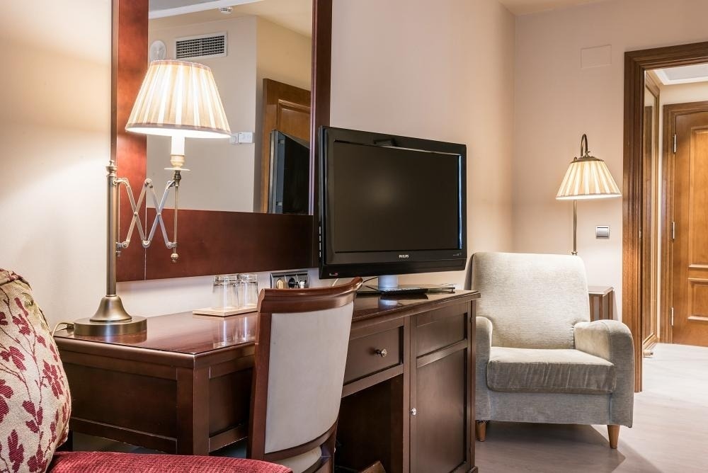 una habitación de hotel con un escritorio y una televisión