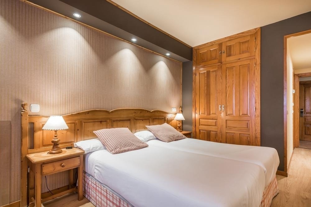 una habitación con una cama y dos mesitas de noche