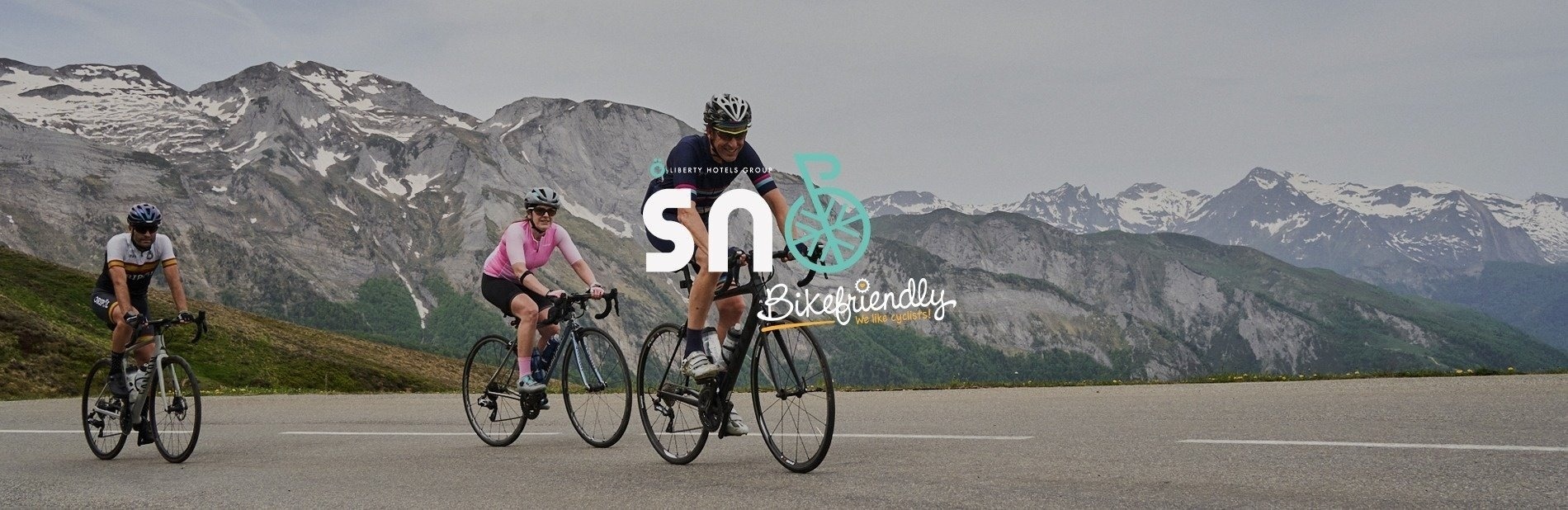a group of cyclists are riding down a road with a logo that says bikefriendly