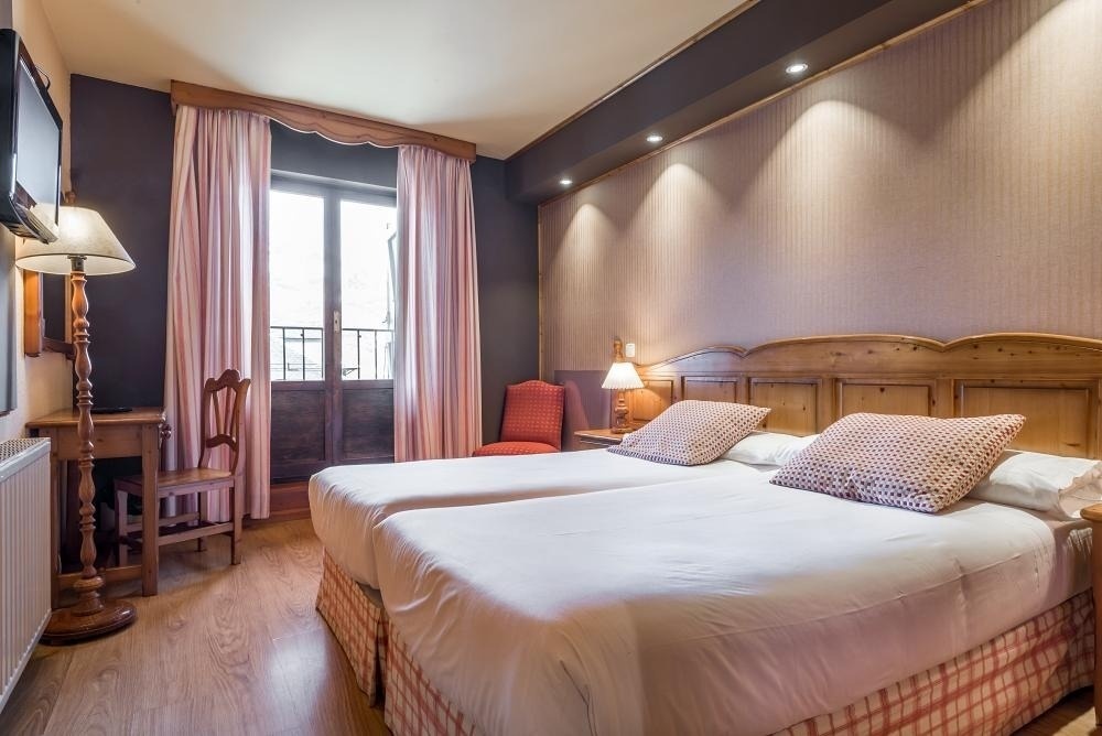 una habitación de hotel con dos camas y una silla