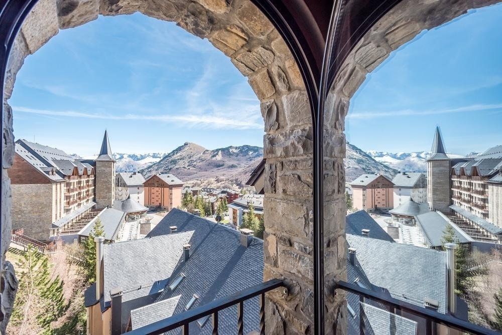 una vista de las montañas a través de una ventana