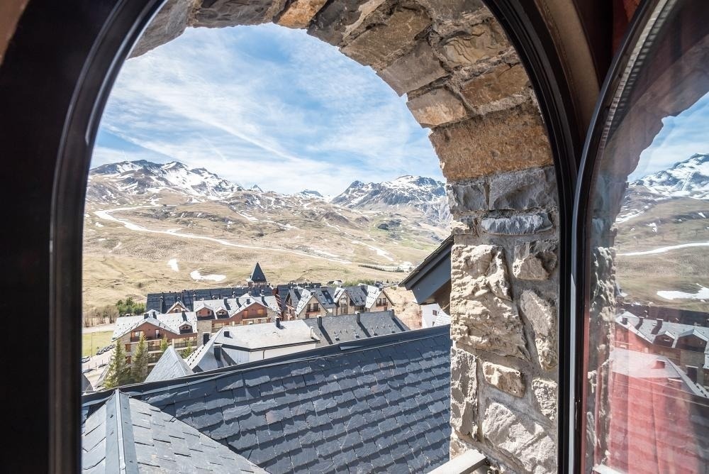 una vista de las montañas a través de una ventana