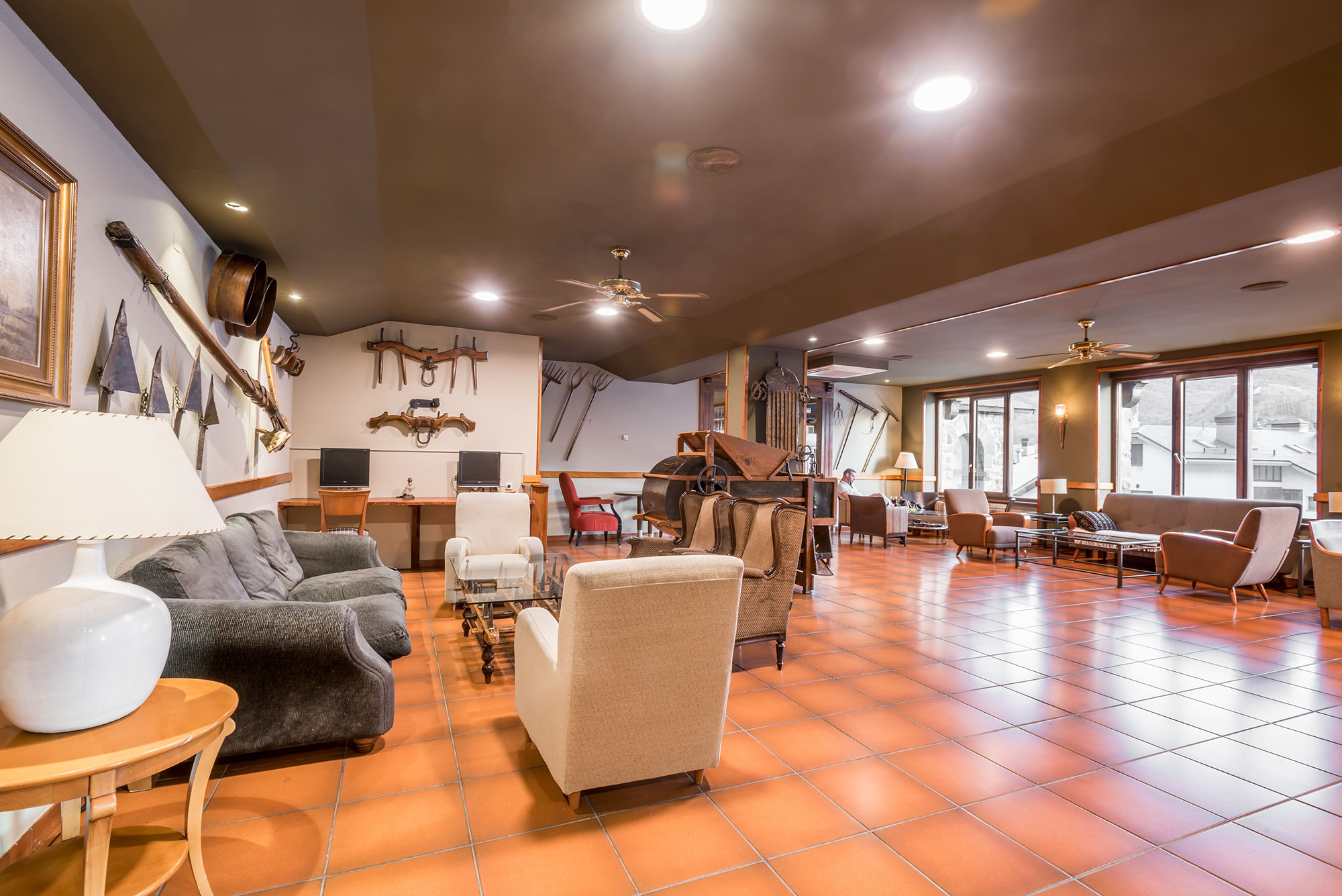 una sala de estar llena de muebles y ventiladores de techo