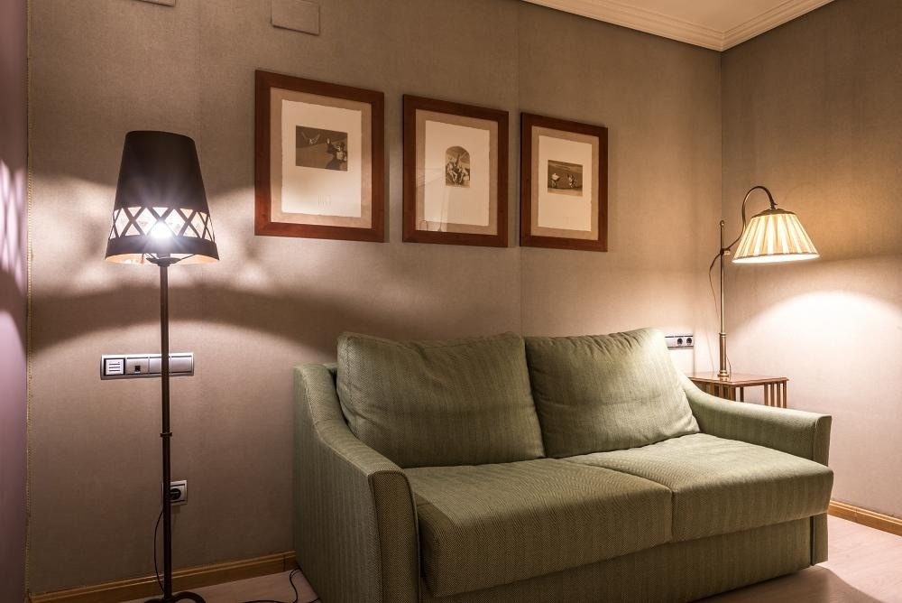 un sofá y una lámpara en una habitación con tres cuadros en la pared