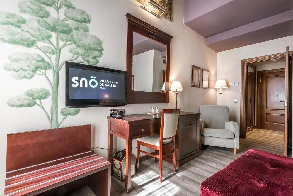 una habitación de hotel con una televisión y un escritorio