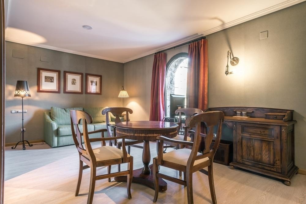 una sala de estar con una mesa y sillas de madera