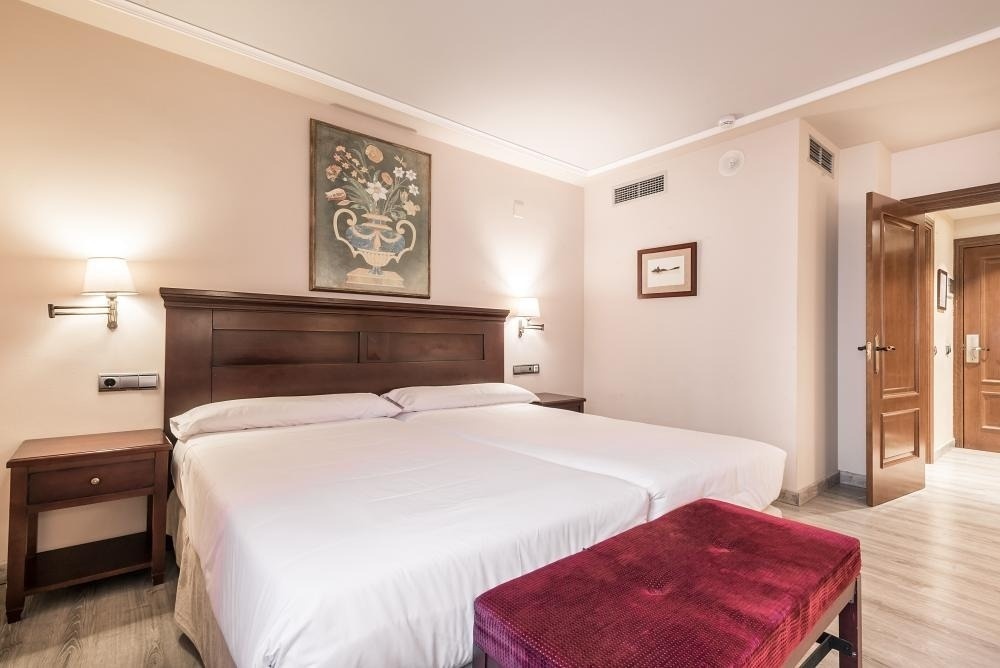 una habitación con dos camas y una pintura en la pared