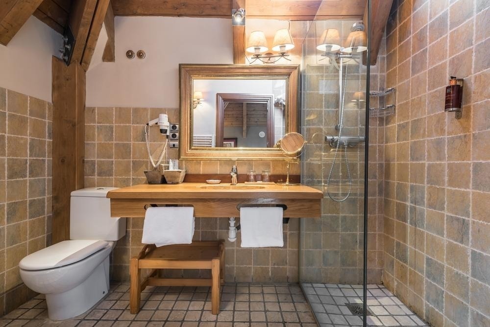 un baño con inodoro , lavabo , espejo y ducha