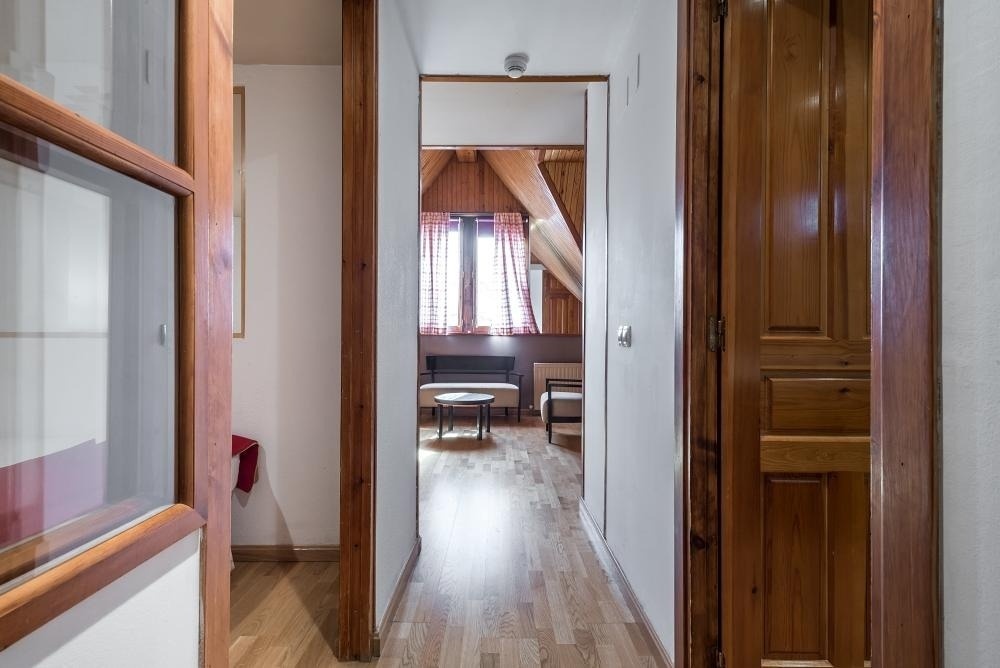 un pasillo que conduce a una habitación con una mesa y sillas