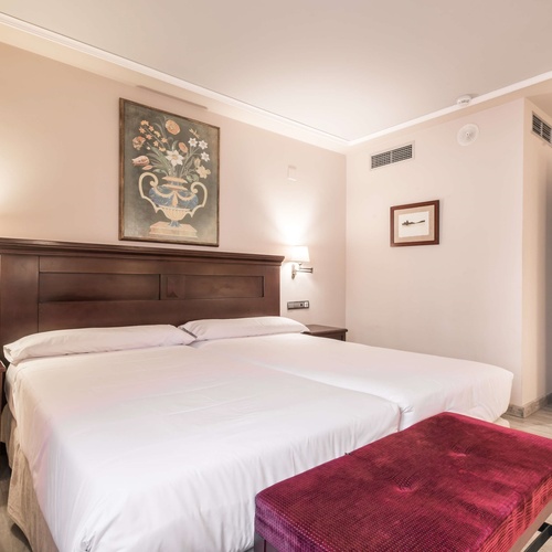 una habitación de hotel con dos camas y una pintura en la pared