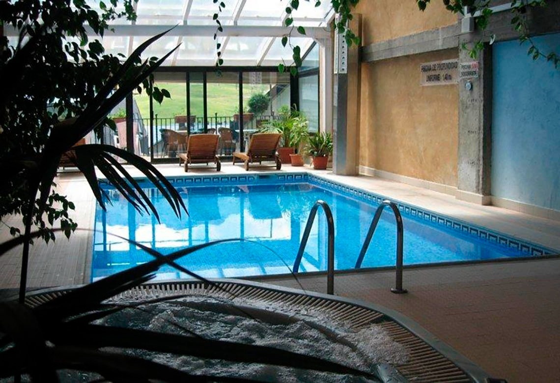 une piscine intérieure avec un jacuzzi à côté d' elle