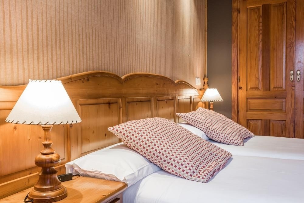 una habitación con dos camas y dos lámparas