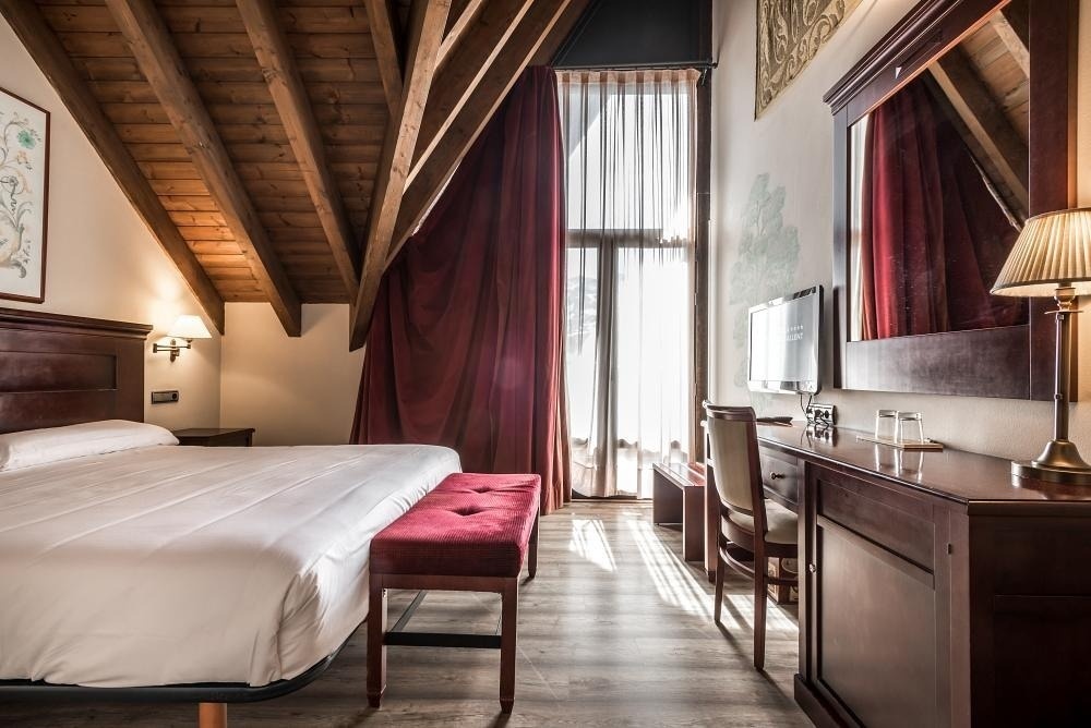 una habitación de hotel con una cama y un escritorio
