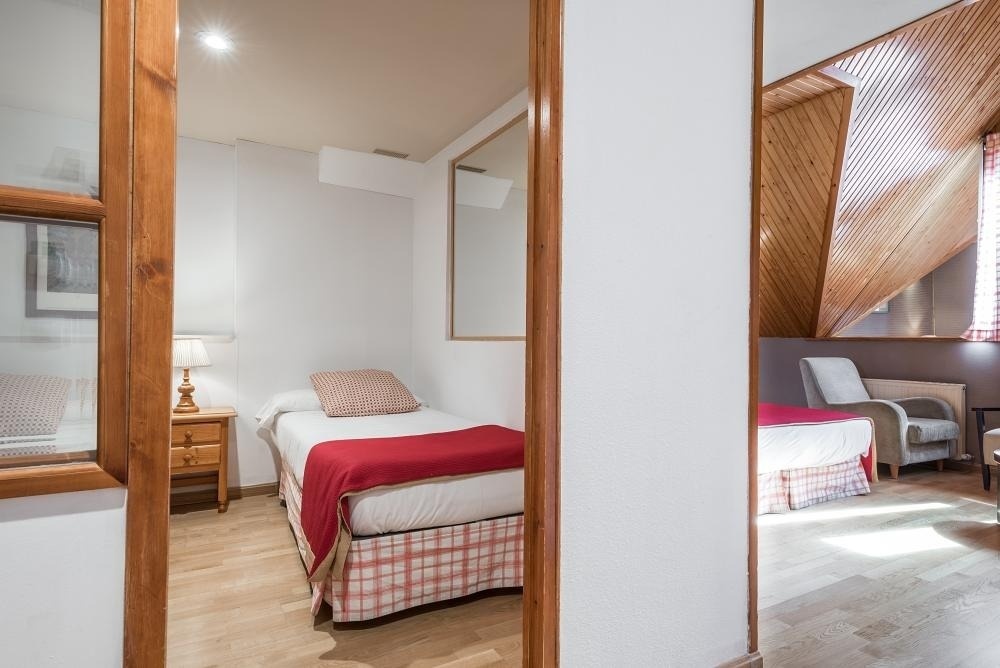 una habitación con una cama y una silla y un espejo