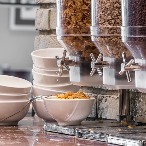 a bowl of cereal sits next to a bowl of coffee
