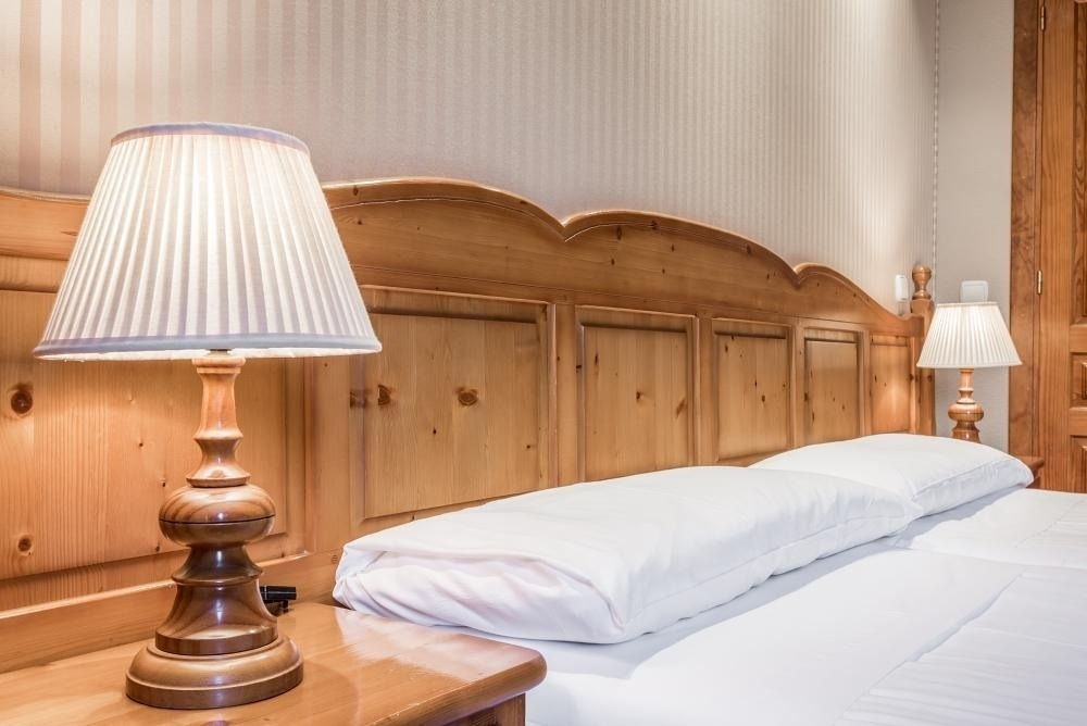 una habitación con dos lámparas y un cabecero de madera