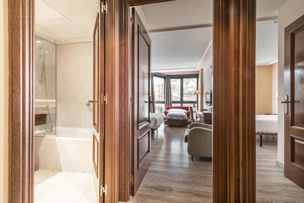 una habitación de hotel con dos camas y una bañera