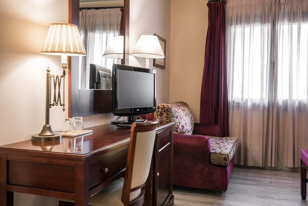 una habitación de hotel con un escritorio y una televisión