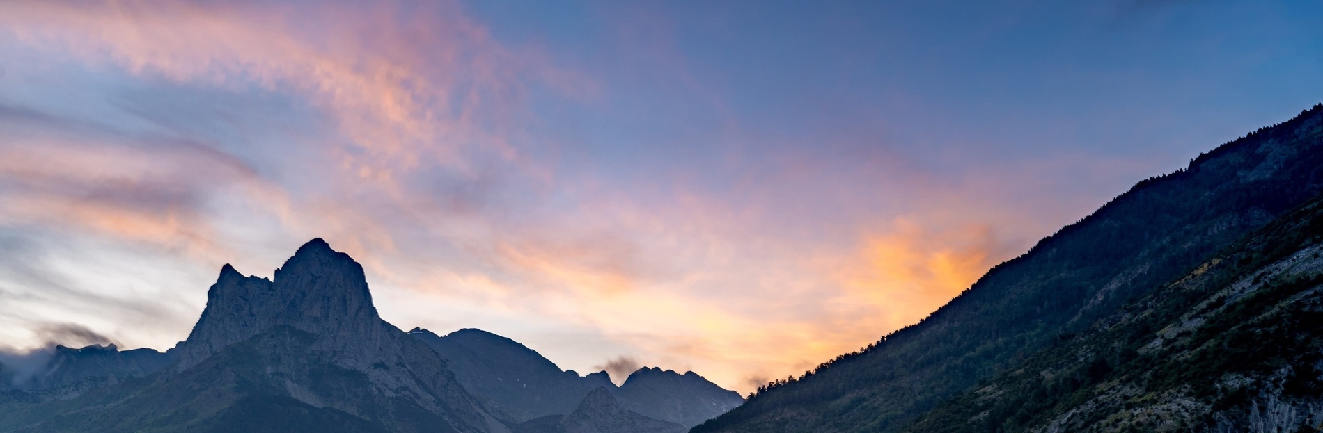 un coucher de soleil coloré sur une chaîne de montagnes