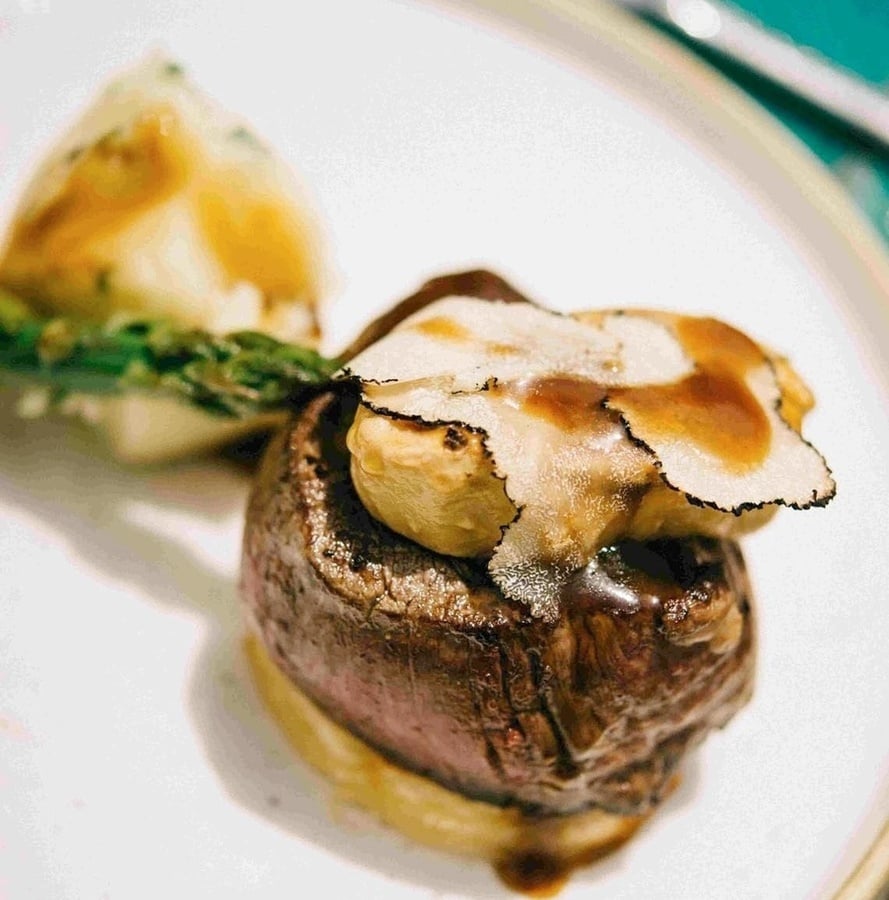 una mesa con un plato de comida y un vaso de jugo de naranja