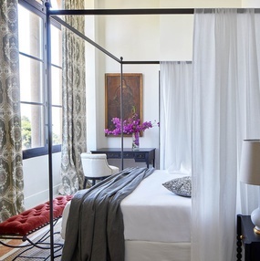 ein Schlafzimmer mit Himmelbett und weißen Vorhängen