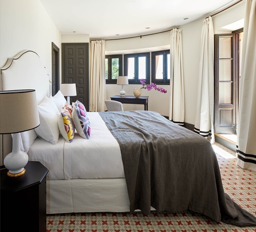 a bedroom with a large bed and two lamps