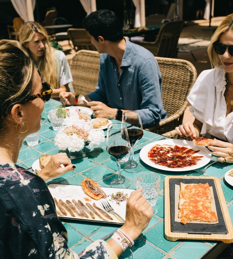una mesa con un plato de comida y un vaso de jugo de naranja
