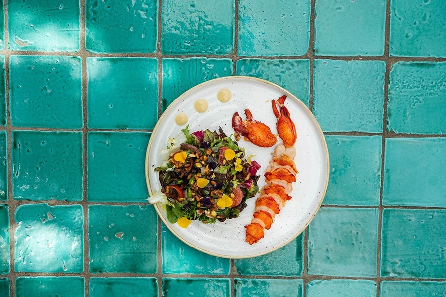 una mesa con un plato de comida y un vaso de jugo de naranja