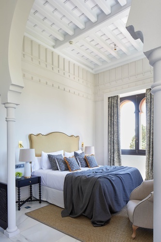 a bedroom with a large bed and two lamps