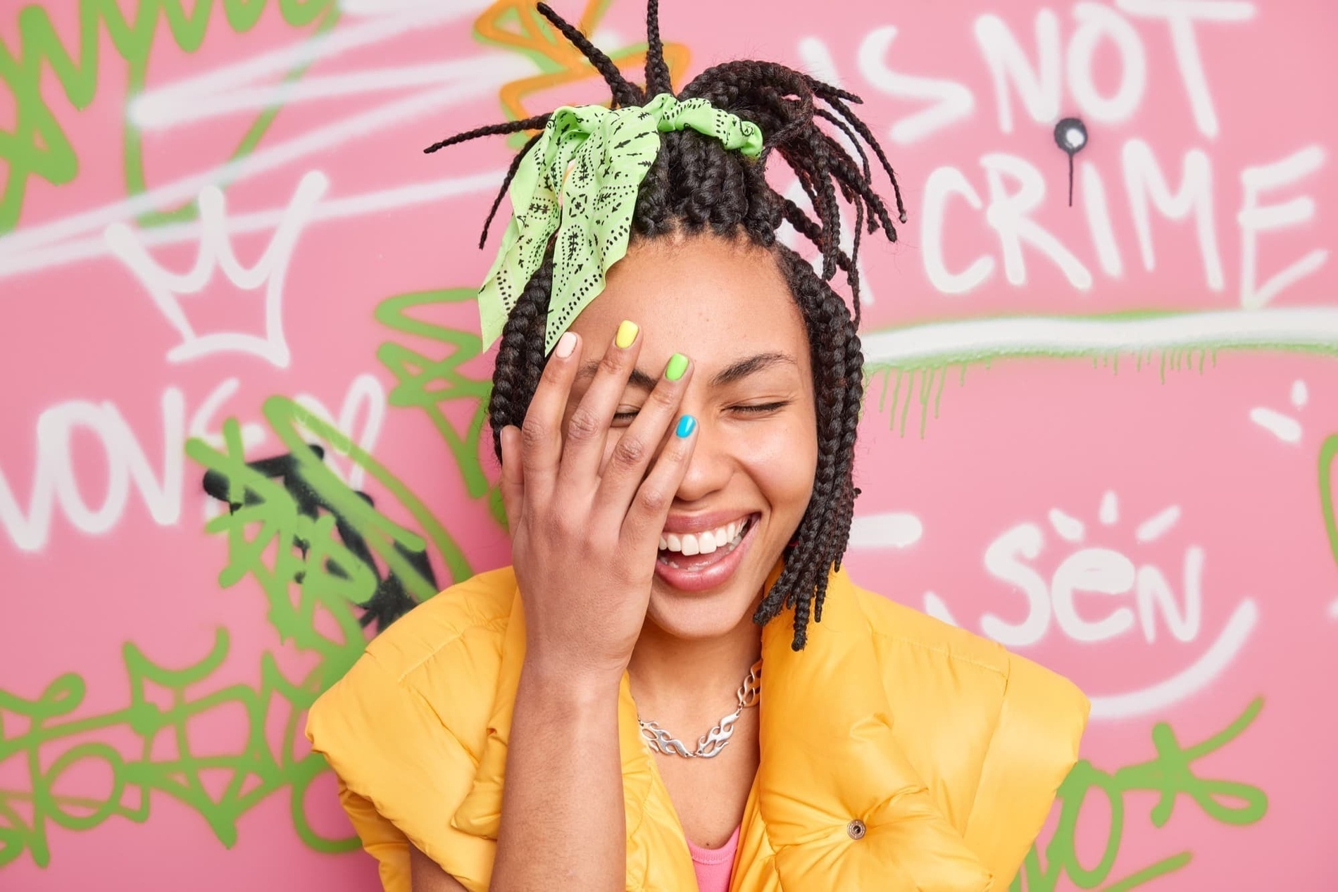 a woman covering her face with her hand in front of graffiti that says not crime