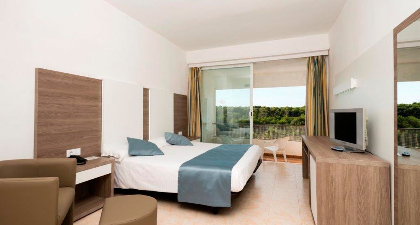 a hotel room with a large bed and a flat screen tv