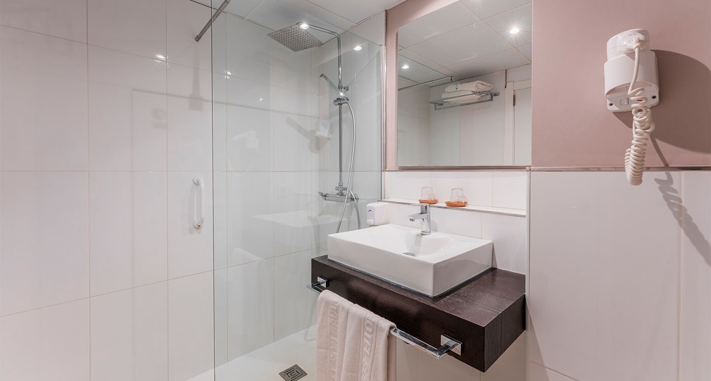 a bathroom with a sink a mirror and a hair dryer